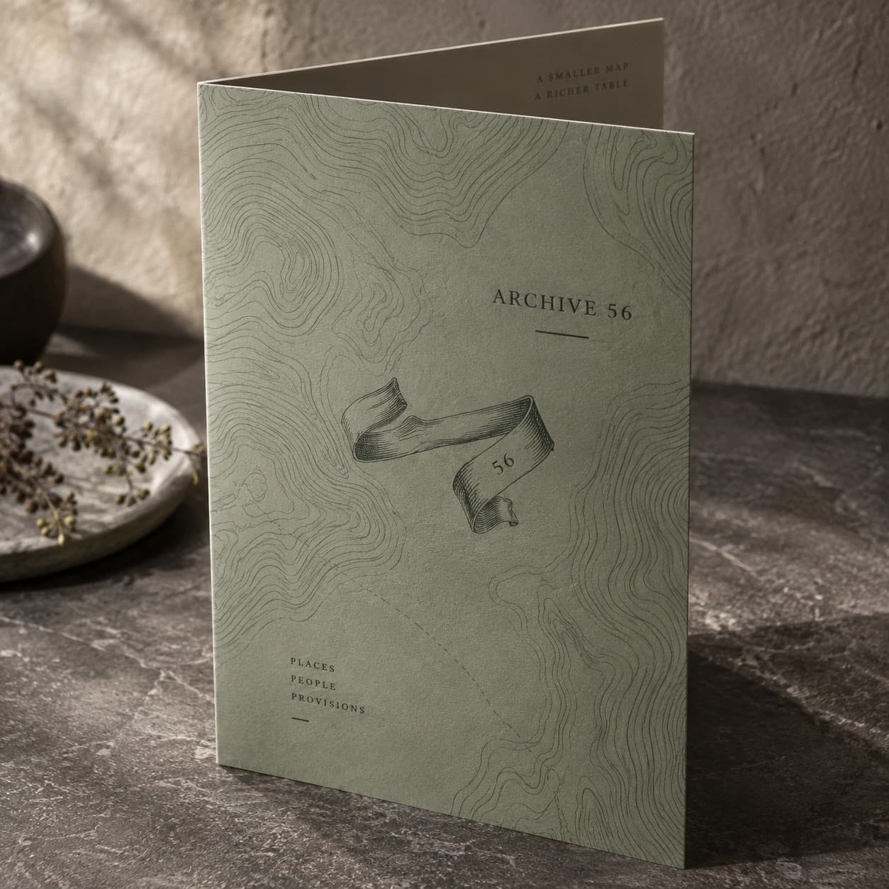 Folded Menus — sage green topographic contour map, with a folded ribbon