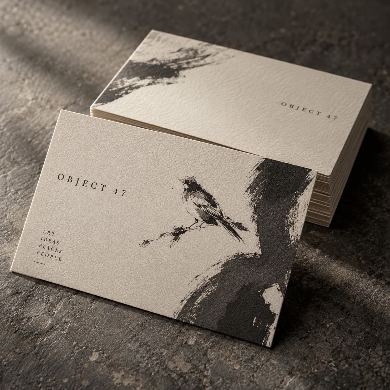 Premium Business Cards — a charcoal abstract brush gesture on warm ivory, with a bird